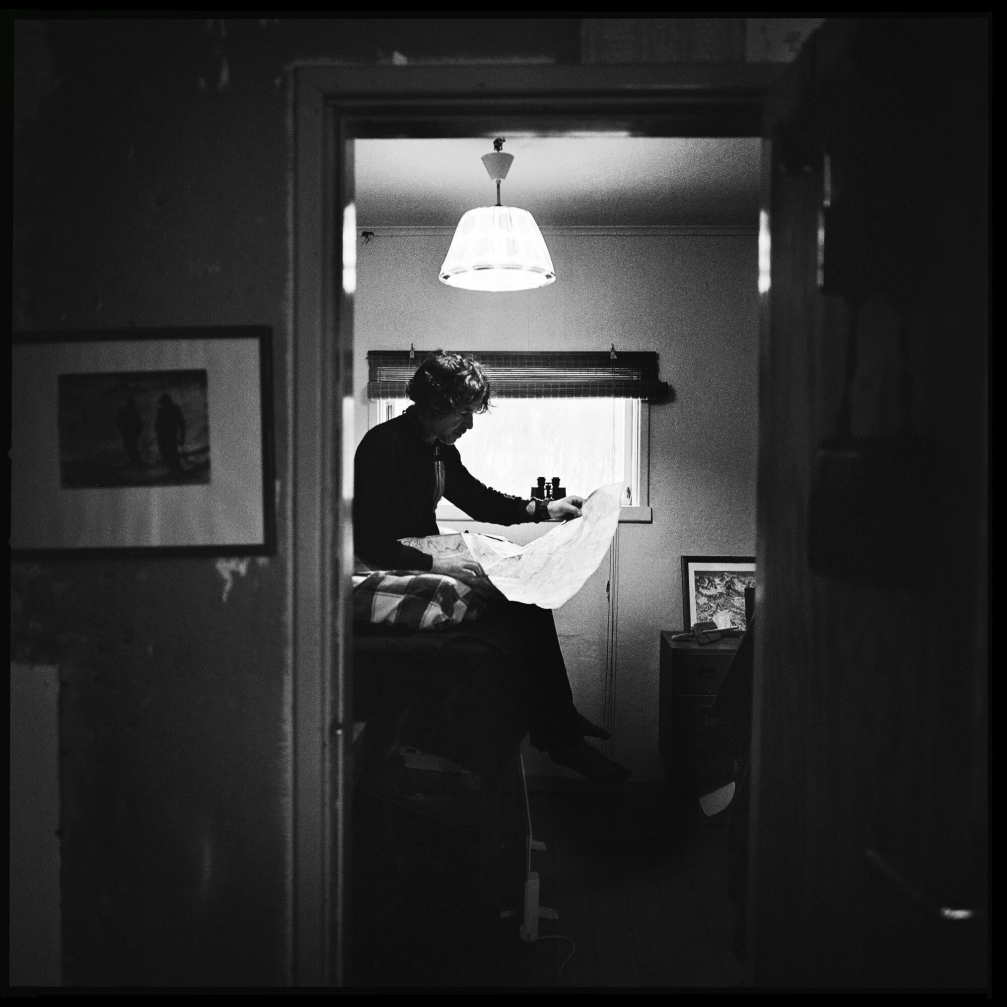 Sven Olofsson in his cabin looking in a map. Stabbfors, Hemavan, Sweden.